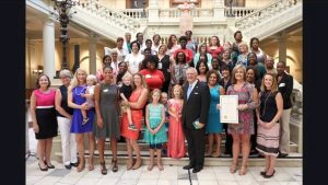 A large group of women and children with the Governor of GA on the staircase in the the GA Capitol building. 